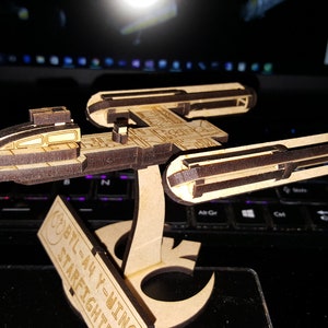 May include: A wooden model of a Star Wars B-wing starfighter, with the text "BTL-A4 Y-Wing Starfighter" printed on the base.