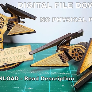 May include: Two wooden models of a TIE Avenger Prototype starfighter from the Star Wars universe. The models are painted in a light brown color and have a detailed design. The text "TIE AVENGER PROTOTYPE" is printed on a sign in front of the models.
