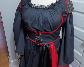 May include: A black and red costume dress with long sleeves. The dress features a lace neckline, a red corset-style bodice, and red trim. A black and red sash hangs from the waist. A tag is attached to the shoulder strap.