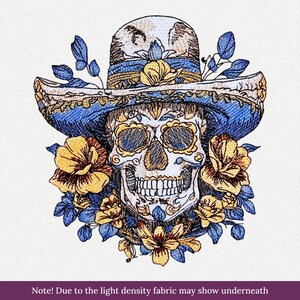 May include: An embroidered patch featuring a human skull wearing a wide-brimmed blue and gold hat, surrounded by yellow and blue flowers. The design includes intricate stitching details on the skull and hat, with a light-colored background.