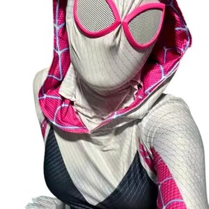 May include: A white and black superhero costume with a hood and pink accents. The costume features a spiderweb pattern and pink-rimmed eye coverings. The costume is made of a stretchy material.