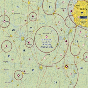 May include: An aeronautical sectional chart centered on Falcon Field in Peachtree City, Georgia. The map features light green terrain, blue airspace boundaries, and red navigation symbols. Text reads: Falcon Field (FFC), Gbird Traveler, First Solo Flight, January 28, 1980, Aircraft C-150, N18587.