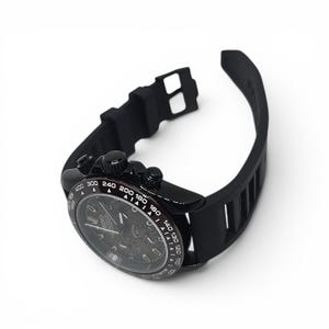 K&ouml;nnte beinhalten: Eine schwarze Chronographen-Armbanduhr mit rundem Geh&auml;use, Tachymeter-L&uuml;nette mit wei&szlig;en Markierungen und schwarzem Silikonarmband. Das Zifferblatt zeigt drei Hilfszifferbl&auml;tter, leuchtende Zeiger und den Markennamen Seiko in wei&szlig;er Schrift.