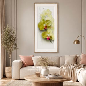 Peut inclure: Une œuvre d'art murale encadrée à la verticale représentant un groupe d'orchidées jaune pâle aux centres magenta vifs. Les pétales sont ornés de petites gouttelettes d'eau, sur un fond clair avec de subtils motifs de lignes grises tourbillonnantes.