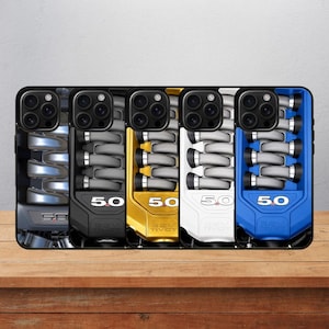 Pode incluir: Cinco capas para smartphone dispostas em fila, cada uma com um gráfico de um coletor de admissão de motor 5.0 32V Ti-VCT. As capas são apresentadas em prata metálico, preto, dourado, branco e azul, com o emblema 5.0 visível em cada unidade.