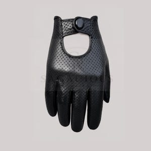 Könnte beinhalten: Schwarzer Leder-Fahrhandschuh mit perforiertem Design. Der Handschuh hat einen Knopfverschluss am Handgelenk und eine große Öffnung auf der Handrückseite. Ein stilvolles und funktionelles Accessoire für das Autofahren.