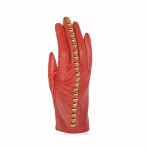 May include: A single red leather glove with a row of gold-colored studs running down the side. The glove is a vibrant shade of red and appears to be made of soft leather. The studs are evenly spaced and add a decorative element to the glove.