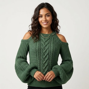 May include: A forest green cable knit sweater featuring cold shoulder cutouts, a crew neckline, and long, voluminous sleeves with ribbed cuffs. The central panel displays a vertical braided cable pattern, while the sides feature a ribbed texture.