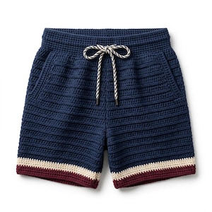 Può includere: Pantaloncini all'uncinetto blu navy con vita in maglia a nido d'ape testurizzata e cuciture a coste orizzontali. L'orlo presenta una striscia color crema seguita da una fascia bordeaux scuro. Un cordoncino intrecciato bianco e blu navy è al centro.