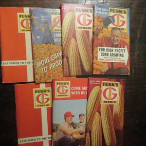 May include: A collection of seven vintage Funk's G Hybrid corn data notebooks and promotional booklets. The items feature orange, white, and yellow color schemes with illustrations of corn, farmers, and text including Seedsmen to the World.