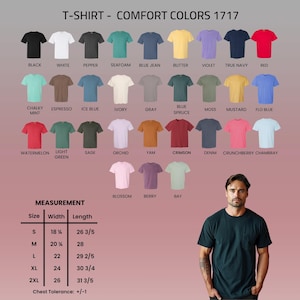 May include: A selection of Comfort Colors 1717 t-shirts in diverse hues, such as black, white, and red. The image features a size chart with measurements in inches, ranging from S to 2XL. A man is wearing a dark green t-shirt.