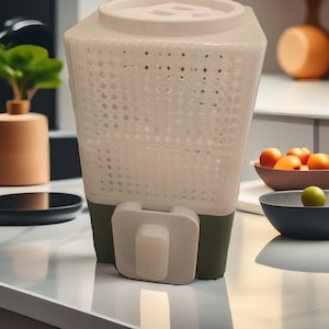 Può includere: Un bidone per compost da cucina bianco e verde con corpo forato e coperchio. Il bidone ha una forma rettangolare con una maniglia sul davanti. Il bidone è su un piano di lavoro bianco.