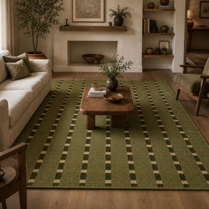 May include: A large rectangular area rug featuring a deep olive green base color with vertical stripes composed of alternating dark green and cream-colored rectangular blocks. The rug has a textured, woven appearance and covers the floor space.
