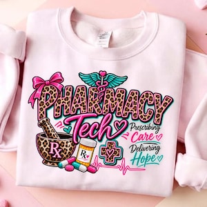May include: A light pink crewneck sweatshirt featuring a graphic with the text PHARMACY TECH, Prescribing Care, and Delivering Hope. The design includes a leopard print mortar and pestle, a pill bottle, capsules, a caduceus, and a pink bow.