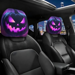 May include: Two black car seat headrests with a Halloween-themed design. Each headrest features a purple and black jack-o'-lantern face with glowing eyes and a sinister grin. The car seats are black leather.