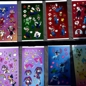 Op de afbeelding: Een verzameling kleurrijke stickerbladen met verschillende stripfiguren. De bladen tonen personages van Sonic the Hedgehog, Super Mario, Spider-Man en andere populaire franchises. Elk blad heeft een witte bovenkant en een levendige achtergrond.