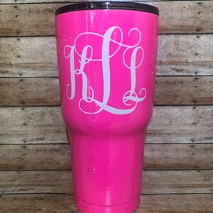 May include: A pink glitter tumbler with a white monogram "KL" on the front.