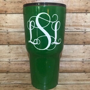 May include: A green glitter tumbler with a white monogram "SL" on the front.