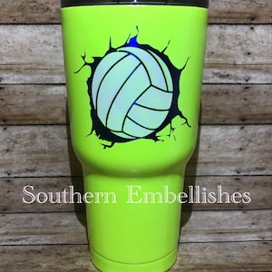 May include: A bright green, stainless steel tumbler with a black and white volleyball graphic. The volleyball is depicted as breaking through the surface of the tumbler. The text "Southern Embellishes" is printed on the bottom of the tumbler.