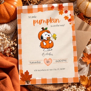 Puede incluir: Una tarjeta de invitación rectangular con borde de cuadros naranjas y blancos, con un perro disfrazado de calabaza con chupete, un pájaro amarillo y hojas de otoño. Texto: A Little pumpkin is on the way! October Saturday 16 6:00 PM 678 Anywhere rd. Any City, FL 56789.