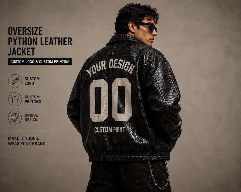 K&ouml;nnte beinhalten: Eine schwarze, &uuml;bergro&szlig;e Python-Lederjacke mit dem Text "YOUR DESIGN" und der Zahl "00" in Wei&szlig; auf dem R&uuml;cken. Die Jacke bietet ein individuelles Logo und individuelle Druckoptionen. Das Bild enth&auml;lt auch den Text "MAKE IT YOURS. WEAR YOUR BRAND."