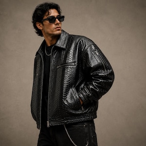 Men’s oversized black python embossed leather jacket with glossy reptile texture, luxury streetwear fashion jacket with premium designer aesthetic.
