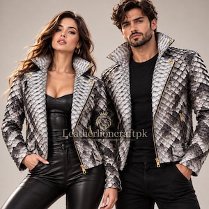 May include: Two jackets featuring a textured, scale-like pattern in shades of grey, black, and white. Each jacket has a wide collar, gold-toned zips, and gold buttons. The text "Leatherlioncraftpk" with a lion logo is centred between the jackets.