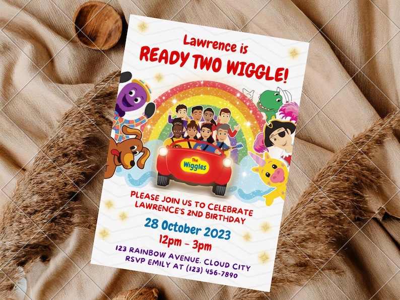 May include: A rectangular birthday invitation card featuring The Wiggles characters, a red car, and a rainbow. The text reads: Lawrence is READY TWO WIGGLE! PLEASE JOIN US TO CELEBRATE LAWRENCE'S 2ND BIRTHDAY 28 October 2023 12pm - 3pm 123 RAINBOW AVENUE. CLOUD CITY RSVP EMILY AT (123) 456-7890.