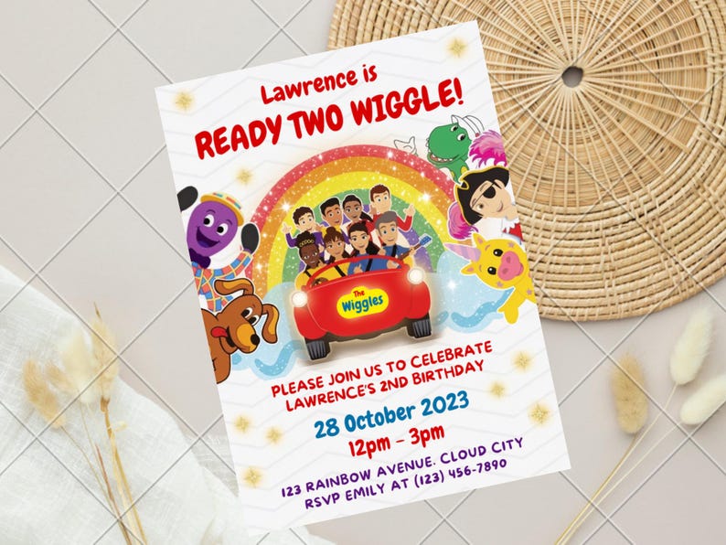 May include: A rectangular birthday invitation card featuring The Wiggles characters, a red car, and a rainbow. The text reads: Lawrence is READY TWO WIGGLE! PLEASE JOIN US TO CELEBRATE LAWRENCE'S 2ND BIRTHDAY 28 October 2023 12pm - 3pm 123 RAINBOW AVENUE. CLOUD CITY RSVP EMILY AT (123) 456-7890.