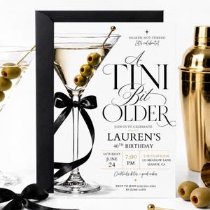 May include: A white birthday invitation card featuring a martini glass with three green olives on a gold pick and a black ribbon tied around the stem. The text reads A TINI BIT OLDER, LAUREN'S 40TH BIRTHDAY, JUNE 24, 7:00 PM, THE PALM ROOM, 123 MEADOW LANE, SEASIDE, CA.