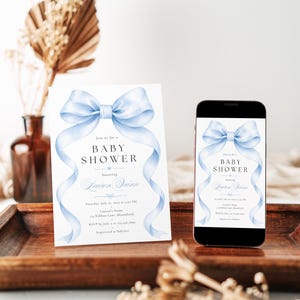 May include: A white baby shower invitation card and a smartphone displaying the same invitation design. Both feature a large, light blue watercolor bow at the top with flowing ribbons and black text that reads: Join us for a BABY SHOWER honoring Lauren Quinn, Saturday, July 16, 2025 at 2:00 PM, Lauren's Home, 123 Ribbon Lane, Bloomfield, RSVP by July 2 to 123.456.7890, Registered at Babylist.