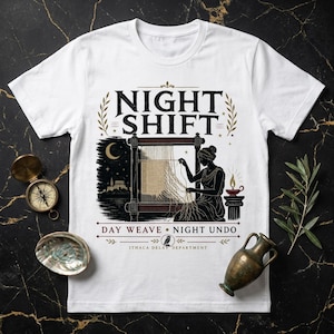 May include: A white t-shirt featuring a black and gold graphic of a person weaving at a loom under a crescent moon. The text reads NIGHT SHIFT, DAY WEAVE NIGHT UNDO, and ITHACA DELAY DEPARTMENT. The design includes an oil lamp and an owl icon.
