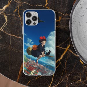 May include: Clear phone case featuring a vibrant illustration of a young witch flying on a broomstick over a city. The design includes a black cat, a blue sky, and fluffy white clouds. The case is made of clear plastic.