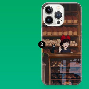May include: Clear phone case featuring a bakery scene with a young girl with a red bow, a black cat, and shelves of bread. The case has a green background and a number 3.