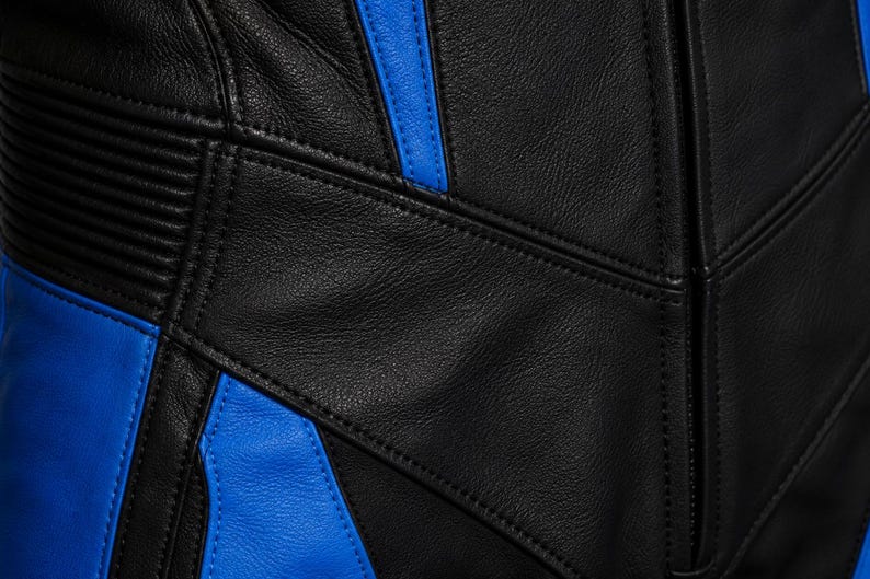 May include: A black and blue leather garment featuring panels of smooth black leather contrasted with vibrant blue leather sections. The piece includes detailed stitching, reinforced seams, and ribbed leather texture accents on the side.
