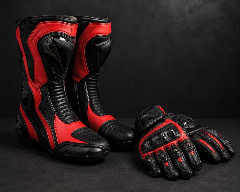 K&ouml;nnte beinhalten: Ein Paar schwarz-rote Motorradstiefel mit verst&auml;rktem Kn&ouml;chelschutz und flexiblen Akkordeon-Eins&auml;tzen, zusammen mit passenden schwarz-roten Motorradhandschuhen mit Hartschalen-Kn&ouml;chelschutz und texturierten Griffdetails.