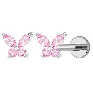 May include: A pair of silver-toned flat back stud earrings, each featuring a butterfly design composed of four pink faceted stones. The butterfly wings are formed by two marquise-cut stones on top and two round-cut stones on the bottom.