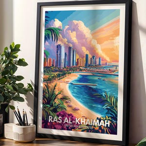 May include: A framed travel poster print featuring a vibrant illustration of the Ras Al-Khaimah coastline, with tall city buildings, a sandy beach, palm trees, and a sunset sky. The text at the bottom reads RAS AL-KHAIMAH UNITED ARAB EMIRATES.