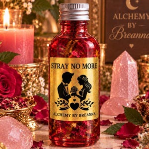 May include: A clear glass bottle filled with red liquid and dried flower petals, topped with a silver screw cap. The gold label features the text STRAY NO MORE and ALCHEMY BY BREANNA, with a black silhouette graphic of a couple holding a rose.