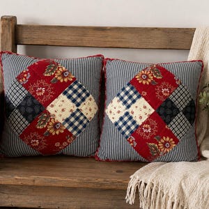 May include: Two square throw pillows featuring a central diamond-shaped patchwork design. The patchwork includes red floral, navy blue gingham, and cream floral fabric squares. The outer border is a blue and white pinstripe fabric.