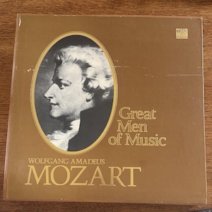 Könnte beinhalten: Eine braune Schallplattenbox mit dem Titel Great Men of Music Wolfgang Amadeus Mozart. Das Cover zeigt ein schwarz-weißes Profilporträt von Mozart in einem ovalen Rahmen und das Logo von Time Life Records in der oberen rechten Ecke.