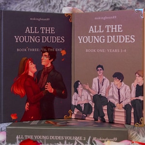 Puede incluir: Colecci&oacute;n de tres libros titulados "All The Young Dudes". Las portadas presentan ilustraciones de personajes y el texto "All The Young Dudes", "Book Three: 'Til The End" y "Book One: Years 1-4". Los libros est&aacute;n en un entorno decorativo.