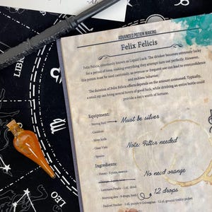 Op de afbeelding: Een oranje drankfles met een kurk, een toverstaf en een pagina uit een drankmaakboek. Het boek beschrijft het recept voor Felix Felicis, ook bekend als Liquid Luck, met een lijst van ingredi&euml;nten en instructies. De tekst "After All This Time?" is ook zichtbaar.