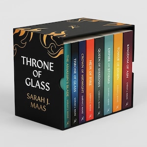 May include: A boxed set of fantasy novels titled "Throne of Glass" by Sarah J. Maas. The black box features gold flame designs and the series title. The book spines are various colors, including teal, navy, orange, and yellow.