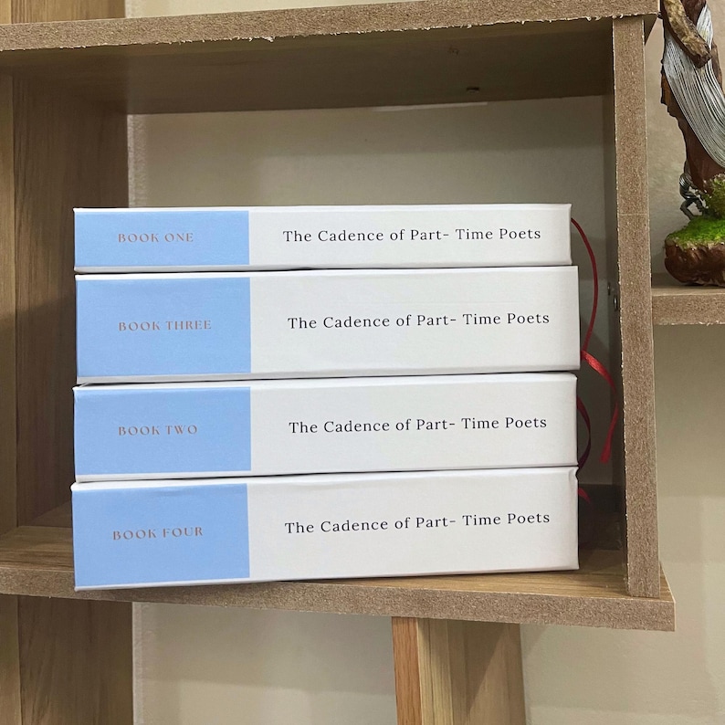 May include: Four books titled "The Cadence of Part-Time Poets" are stacked on a wooden shelf. Each book has a white cover with a light blue band at the top, displaying "BOOK ONE", "BOOK THREE", "BOOK TWO", and "BOOK FOUR".