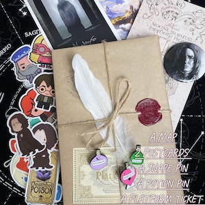 Op de afbeelding: Een cadeaupakket met een bruin papieren pakketje vastgebonden met touw, een witte veer en een rode zegel. Inclusief een kaart, twee ansichtkaarten, een Snape-speld, een drankspeld, een perronkaartje en stickers. Tekst op het pakket luidt "A Map, 2 Postcards, A Snape Pin, A Potion Pin, A Platform Ticket, Free Gift Wrapping, Stickers."
