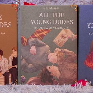 Puede incluir: Tres libros con portadas ilustradas. El primer libro es marr&oacute;n con el texto "THE DUDES YEARS 1-4". El segundo libro es verde con el texto "ALL THE YOUNG DUDES BOOK TWO: YEARS 5-7". El tercer libro es azul con el texto "ALL THE YOUNG DUDES BOOK THREE".