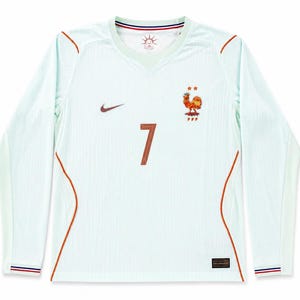 Puede incluir: Una camiseta de fútbol de manga larga en color verde menta claro con un logo Nike marrón oscuro en el pecho derecho y el escudo de la selección francesa con dos estrellas a la izquierda. El número 7 está impreso en marrón oscuro en el centro.