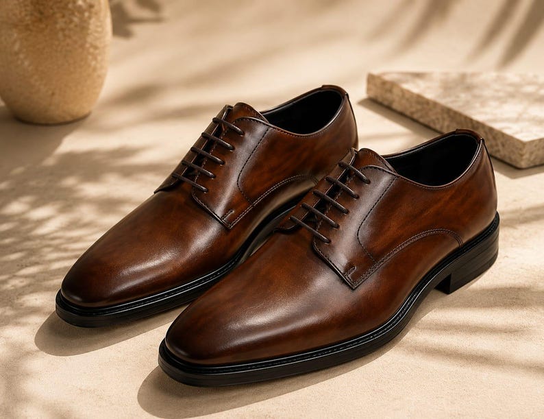 May include: A pair of dark brown leather oxford shoes featuring a burnished finish, a rounded toe, thin dark brown laces, and a solid black sole. The shoes have a smooth, polished surface with visible stitching along the eyelet panels and heel.