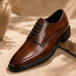May include: A polished dark brown leather oxford shoe featuring a classic closed-lacing system, a rounded toe, and a solid black sole. The shoe displays a smooth, burnished finish with tonal stitching details along the eyelet panels and heel.